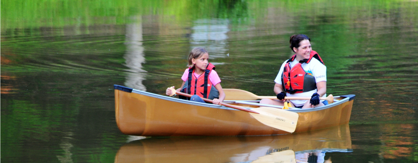 Mother and daughter canoe on a lake