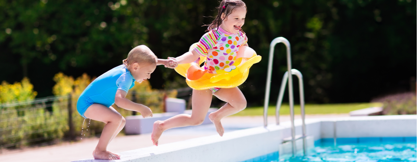 Kids jumping in backyard pool