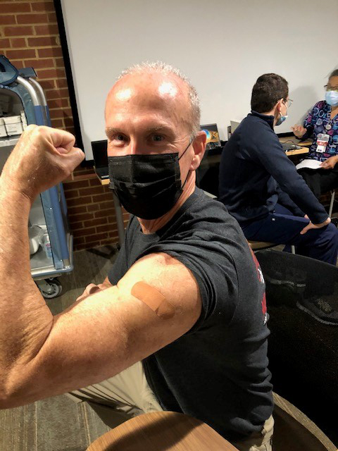 Michael Minogue shows off the bandaid on his arm from his vaccine
