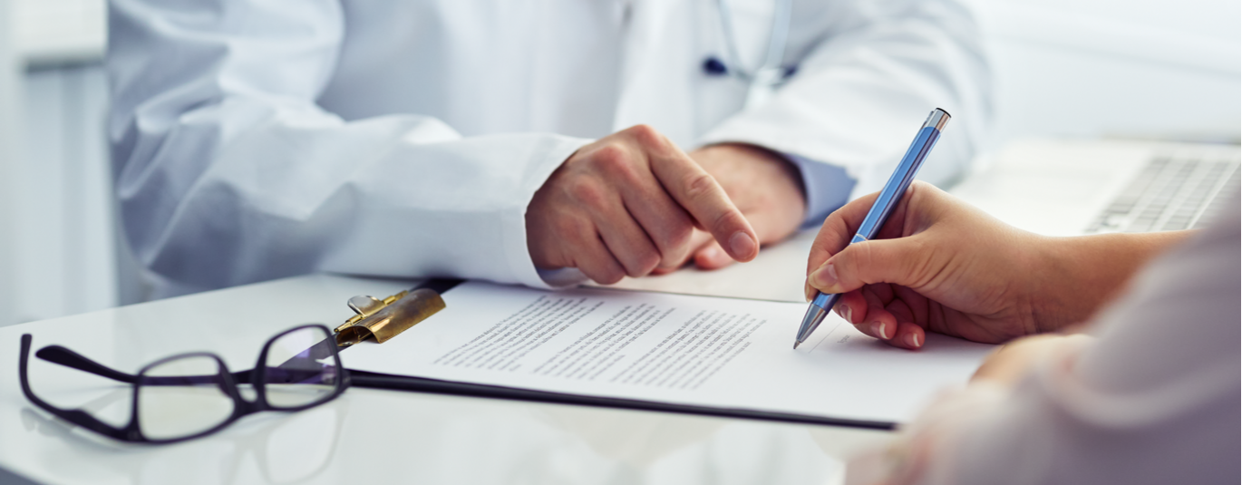 Doctor and patient fill out forms on a clipboard