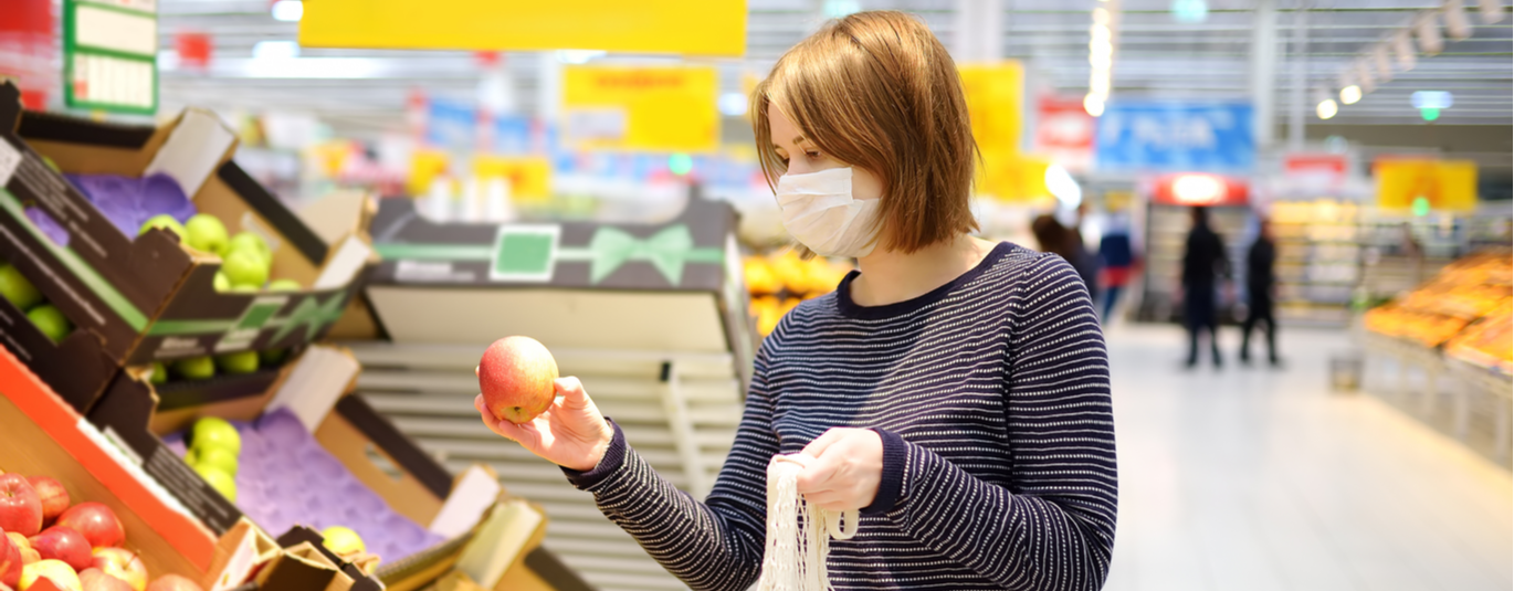 Young woman wears face mask while shopping for groceries